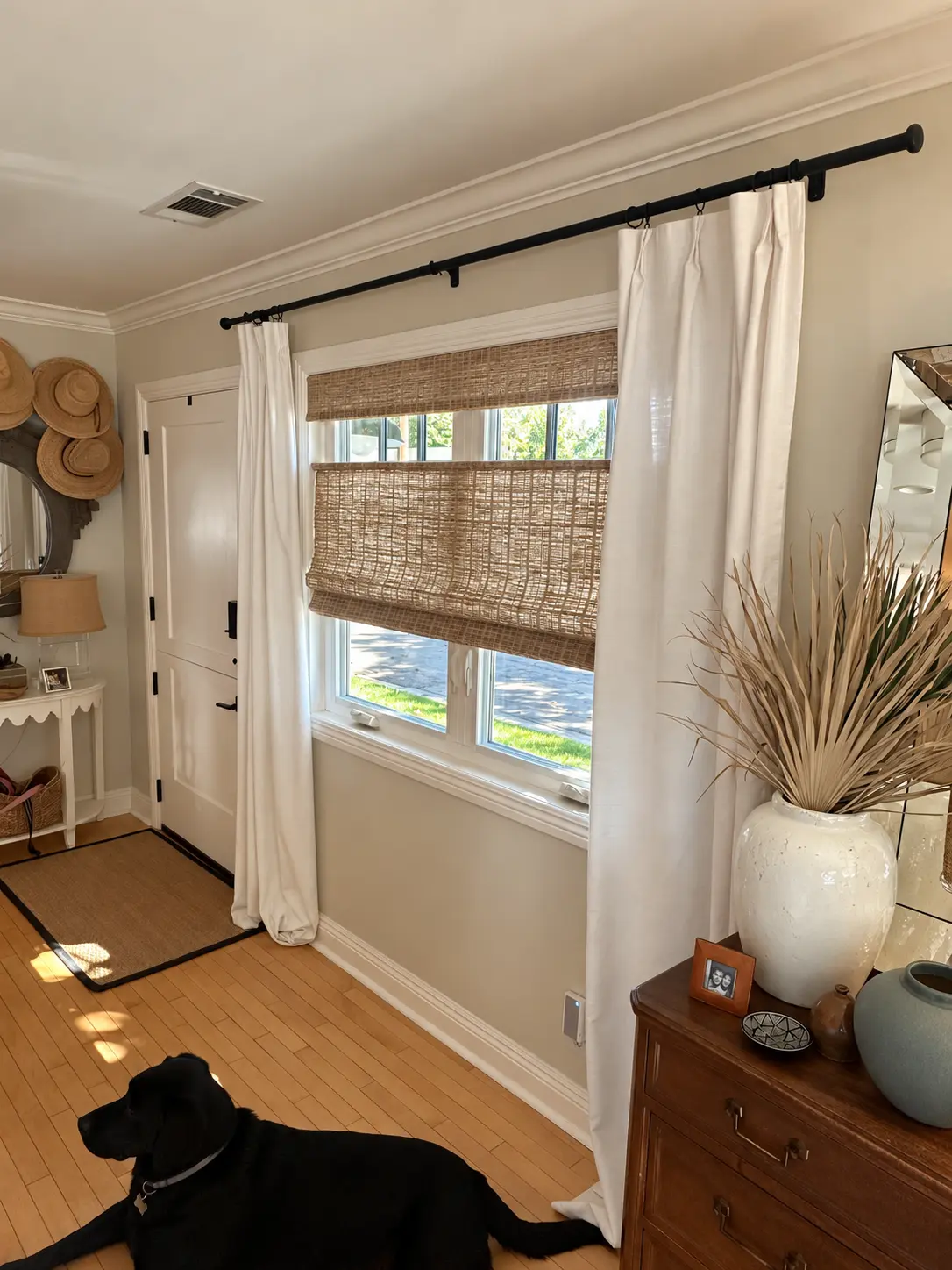 Entryway with a Fiji Sandy Fawn natural shade, white drapes and black metal rod beside the entrance door