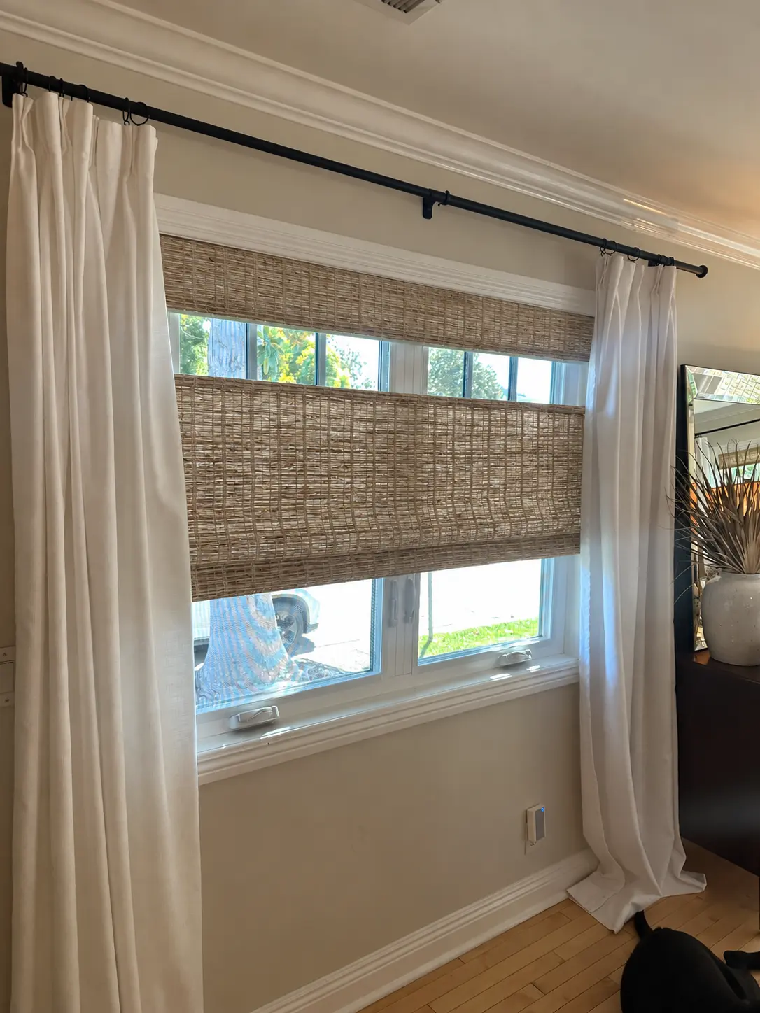 Closer view of the entryway’s top-down/bottom-up natural shade between ivory curtains